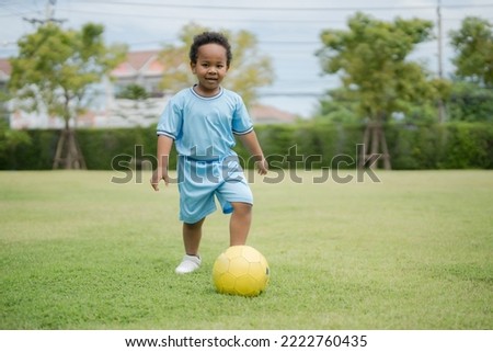 Cute little boy with soccer ball in the park on a sunny day have come out to play outside with fun.