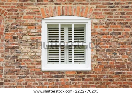 Exterior of old brick house with wooden sash window and wooden blinds, England, UK Royalty-Free Stock Photo #2222770295