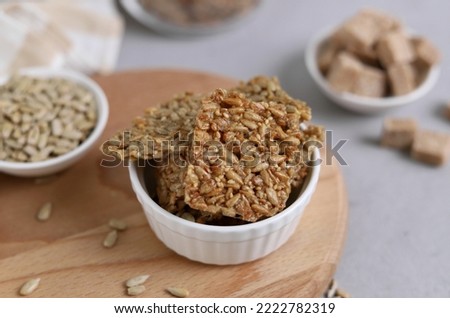 Oriental sweetness with sunflower seeds and sesame seeds in a white bowl close-up. Kozinaki. Selective focus.