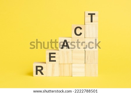 wooden cubes with text react. yellow background.