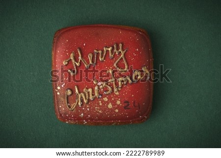 Delicious Christmas cookie from Advent calendar to count the days in anticipation of Christmas. Gingerbread cookie with festive icing on the green background. Merry Christmas and Happy New Year