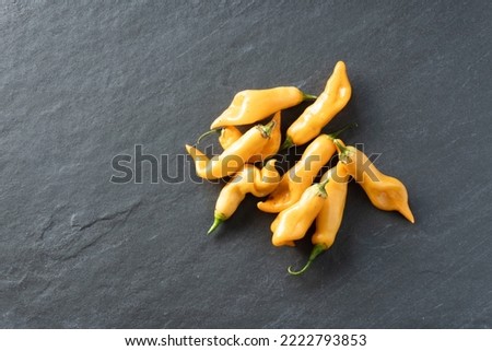 Heirloom bright gold sugar rush peach peppers on a gray slate background; food Royalty-Free Stock Photo #2222793853