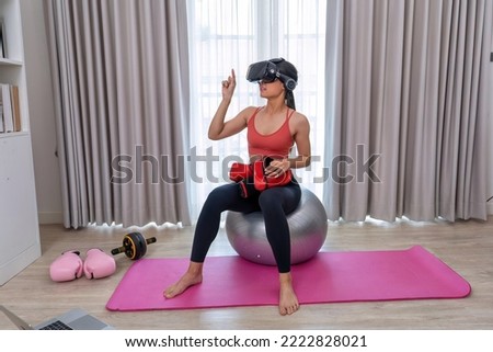 beautiful lady pilate yoga sitting on exercise ball wearing VR imagination hand draw on air
