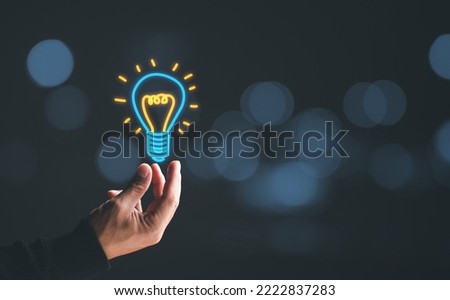 Hand of man holding graphic illuminated light bulb, idea, innovation and inspiration concept. concept creativity with bulbs that shine glitter.