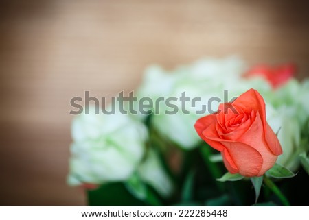 bouquet of red and yellow roses on a wooden dark background