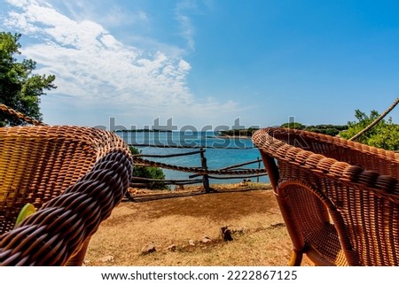 relaxing panorama between blue sea and wicker armchairs with wooden fence in the Brijuni islands in Croatia