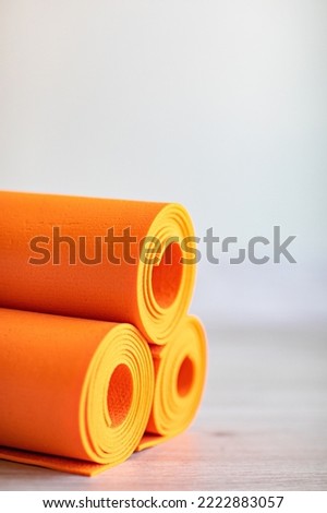 orange rolled up yoga and gymnastics mats on the floor. equipment for fitness and gyms and clubs. Royalty-Free Stock Photo #2222883057