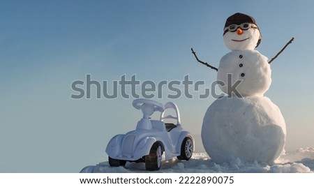 Snowman driver on the snow outdoor background. Christmas banner with snowman. New year greeting card with with snowman.