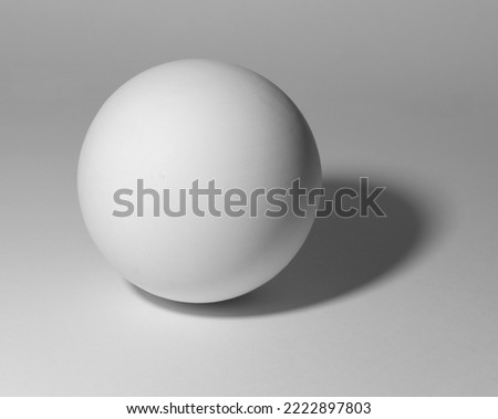 White sphere on white background. Plaster ball with shadow for academic drawing. Royalty-Free Stock Photo #2222897803