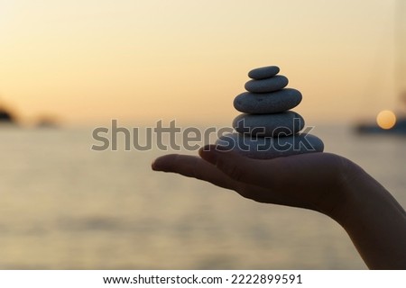 Zen stones background. Tower of stones on the sea beach on a summer evening. Meditation, calmness, peace, mental health concept.