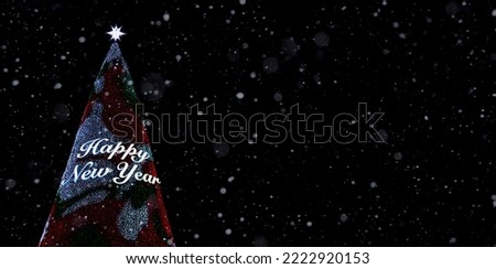 Christmas tree with illumination and the inscription Happy New Year against a dark night sky