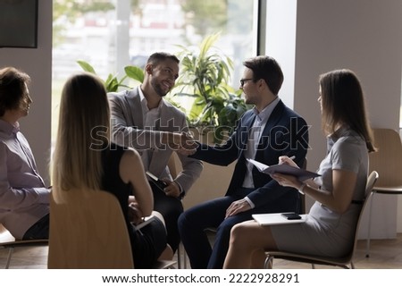Business partners shake hands after successful negotiations, make profitable commercial deal feel satisfied, accomplish business meeting. Greeting of two colleagues at morning briefing event in office Royalty-Free Stock Photo #2222928291
