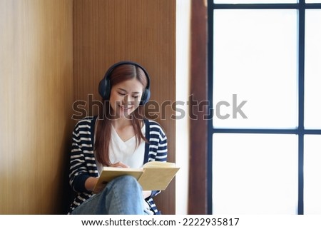 Portrait of a loving Asian teenage girl wearing headphones using a notebook while listening to an online lesson.