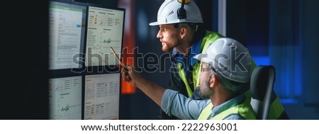 Two engineers follow assembly process uses SCADA system. Group of operators control process on product line uses industry 4.0 and digital technology on modern factory Royalty-Free Stock Photo #2222963001