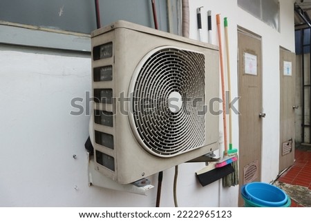 An outdoor unit of an air conditioner mounted on the wall.