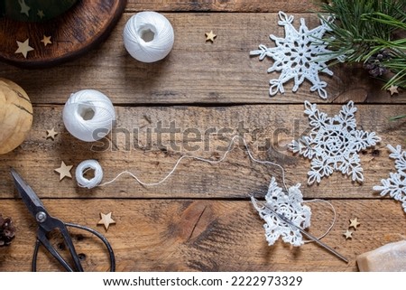 Handmade white yarn snowflakes on wooden table, copy space, horizontal