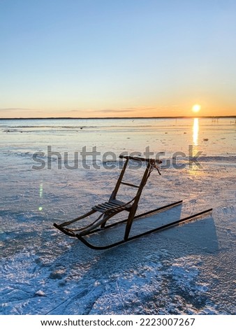 VIntage wooden kicksled on lake in scandinavia with sunset in background. WInter adventures. Kicksled, sled, spark. Outdoor christmas.