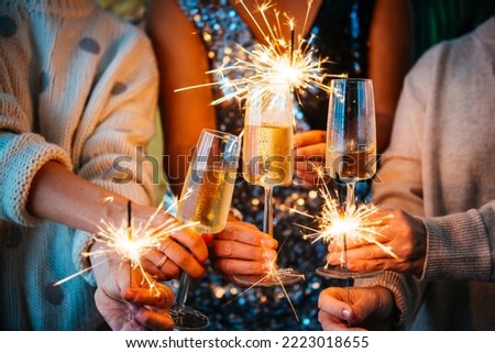 Friends celebrating Christmas or New Year's eve with Bengal lights and champagne.


 Royalty-Free Stock Photo #2223018655
