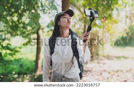happy women enjoying nature travel.female traveler carrying a backpack.A woman happily uses a mobile phone to take pictures