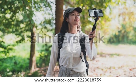 happy women enjoying nature travel.female traveler carrying a backpack.A woman happily uses a mobile phone to take pictures