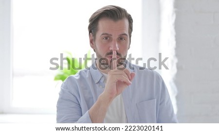 Young Man Putting Fingers on Lips, Quiet Sign