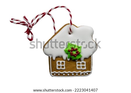 Ginger cookies with icing in the form of a house as a Christmas tree toy on a white background. The concept of Christmas decorations and sweets.