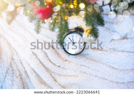 Beautiful Christmas photo with Christmas tree decorated with glowing garlands, Clock under the decorated Christmas tree and space for copy