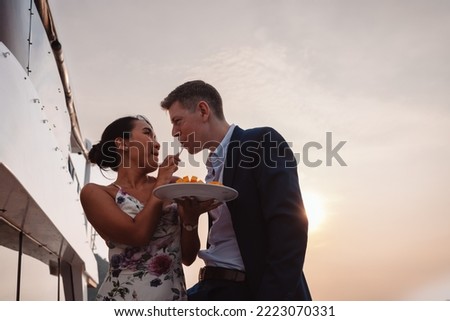 Romantic couple embracing together, Man and woman enjoying with honeymoon on luxury yacht. Having fun together at sunset, weekend activity lifestyle concept.