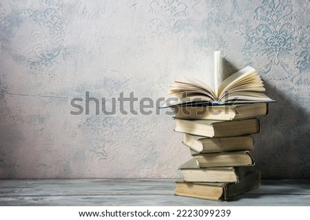 Vintage old hardback books, diary, fanned pages on wooden desk table and grunge background Daylight. Books stacking. Back to school. Copy Space. Education background Royalty-Free Stock Photo #2223099239