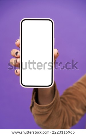 Mature woman hand with smartphone with white screen isolated on white background. Modern phone with touch screen in woman hand. Close up. Mock up mobile app advertising. No face visible.