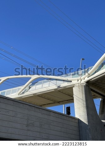 Low angle shot of a modern white bridge under blue sky on sunny day