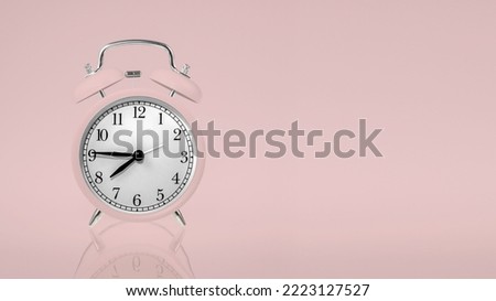 retro alarm clock in pastel pink on a pastel background with space for any text