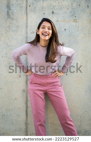 Portrait happy young woman laughing with hands on hips