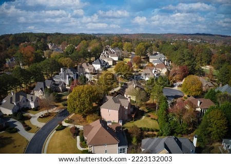 A Panoramic aerial view of a beautiful sub division shot by a drone with beautiful houses ,manicured lawns and tree with changing color during fall in suburbs of Atlanta, GA,USA Royalty-Free Stock Photo #2223132003