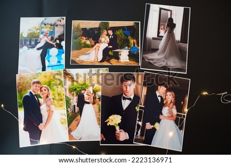 printed wedding photos on a black background. the concept of preserving the memory of an important event, the services of a professional photographer for the celebration and typography.