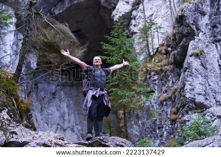 Professional nature photographer with backpack hiking and shooting in a large cave in the limestone mountains