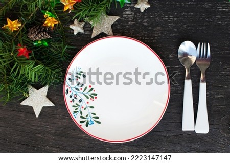 New Year's table setting. Christmas decor with a luminous garland, stars, a new year tree and cones on wooden background. Top view