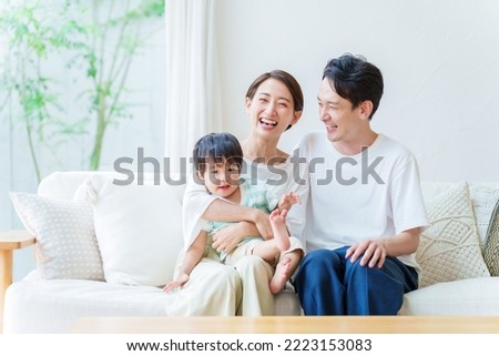 asian parents and boy relaxing in the living room