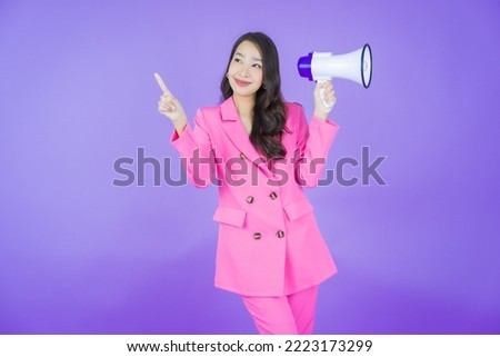 Portrait beautiful young asian woman smile with megaphone on color background