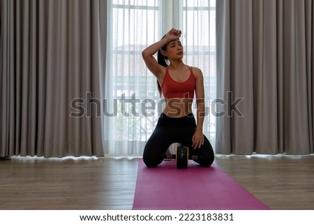 Young lady meditation pilates hold hand roller exercise on the foam mats in the leaving room