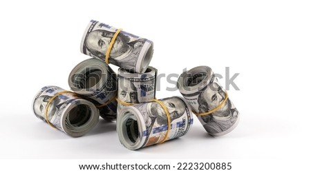 Several rolled-up bundles of 100 American dollars bills on white  background Royalty-Free Stock Photo #2223200885
