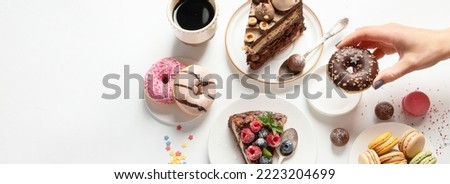 Various cookies, donuts, cakes, cheesecakes and coffee cups on white background.  Delicious dessert table. Top view, flat lay, panorama, banner Royalty-Free Stock Photo #2223204699