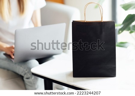 Creative promotion composition for Black friday with laptop and shopping bag on working desk. 