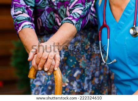 Young doctor supporting the disabled elderly - conceptual image.