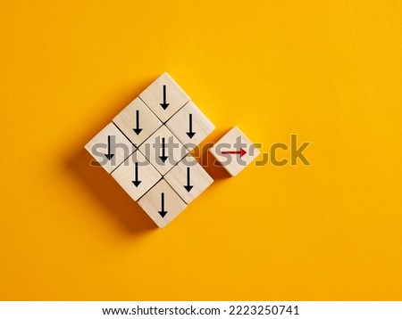 One arrow moves the opposite direction than the others. Unique, think different, individuality, standing out from the crowd and choosing a different path in business and life concepts. Royalty-Free Stock Photo #2223250741