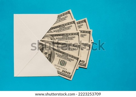 Dollar banknote saving money in envelope on blue background copy space. Consumption and economy Collecting money. Tips. Business, finance, saving, banking and people concept. Extra money, passive
