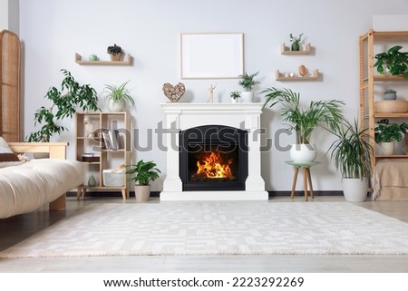 Stylish living room interior with fireplace, houseplants and beige sofa