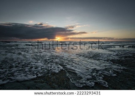 Sunset on the beach in Denmark. Waves on the sand. Walk on the coast in the sand. Landscape photo by the sea