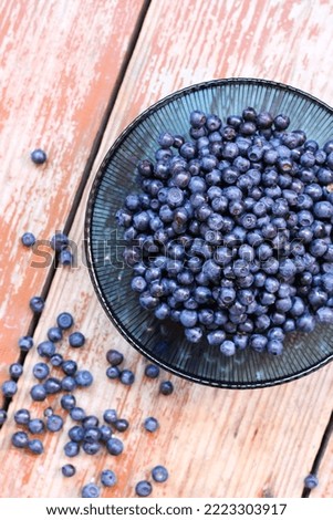 Fresh blueberries in bowl on wooden background