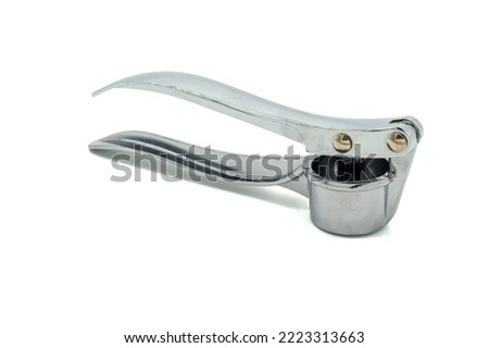 Garlic press is a kitchen utensil designed to crush garlic over a sieve with small holes.Isolated on white background Royalty-Free Stock Photo #2223313663